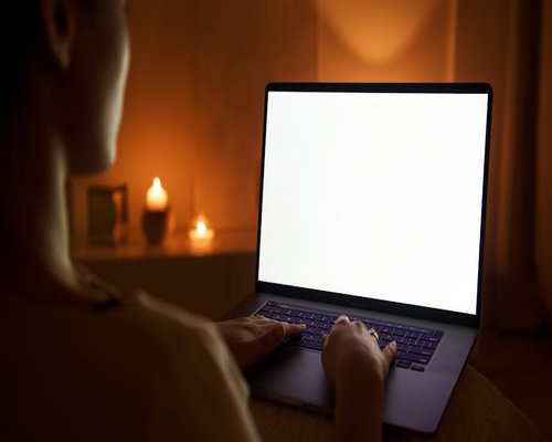 person working on laptop with soft ambient bias lighting